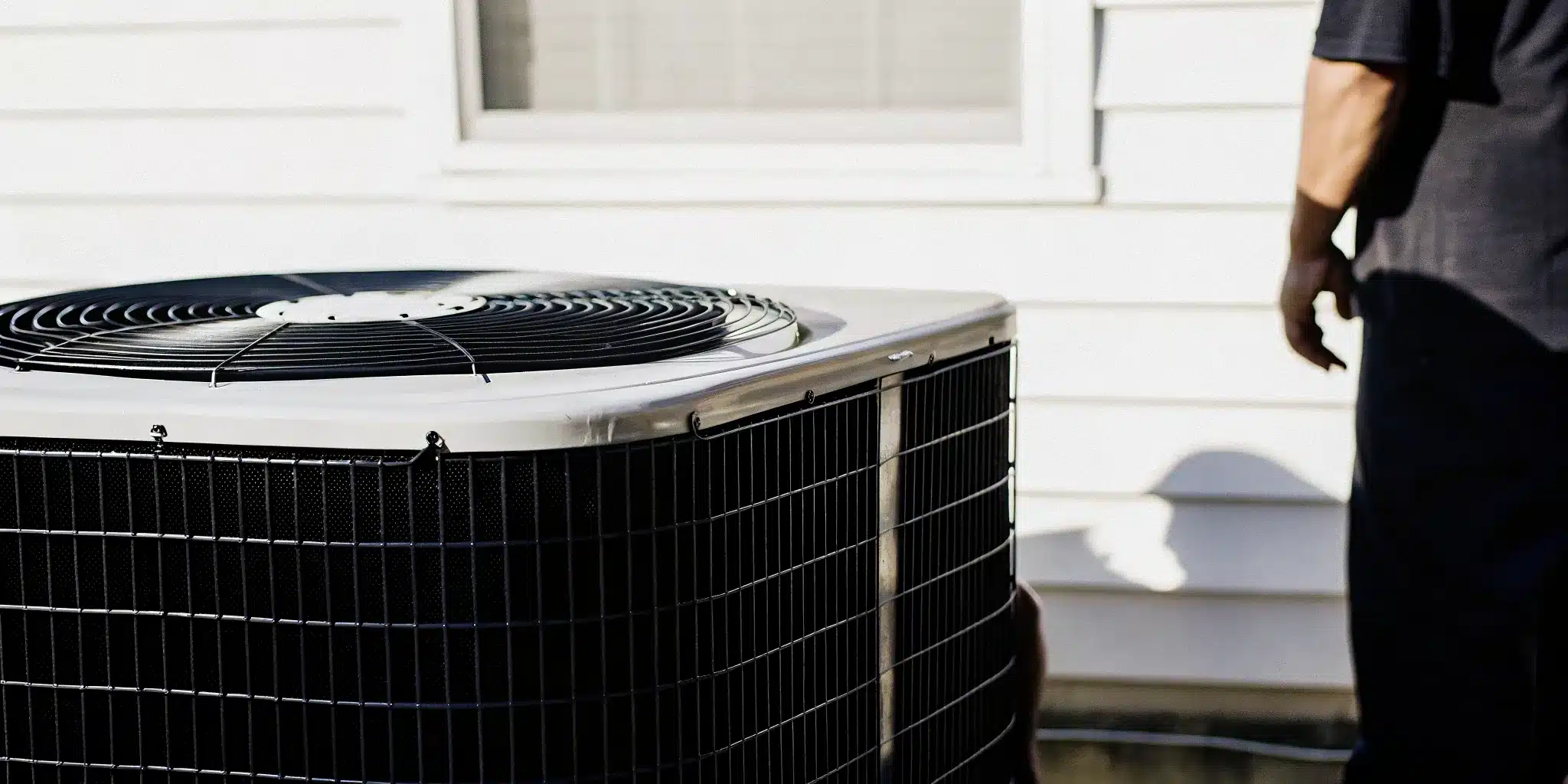 Homeowner checking thermostat as warm air blows from AC vent, Indianapolis summer